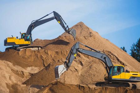 工廠的金屬廢料堆和大型推土機黃色的重型挖掘機和推土機開挖砂和新